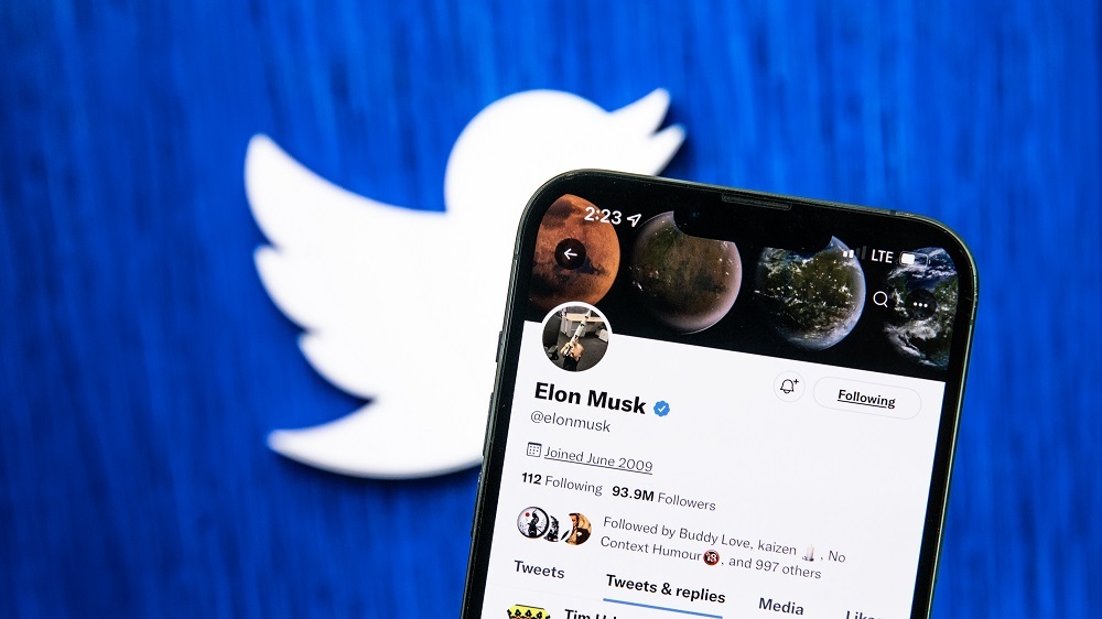 Musk氏のTwitterアカウントを表示したスマートフォンとTwitterのロゴ